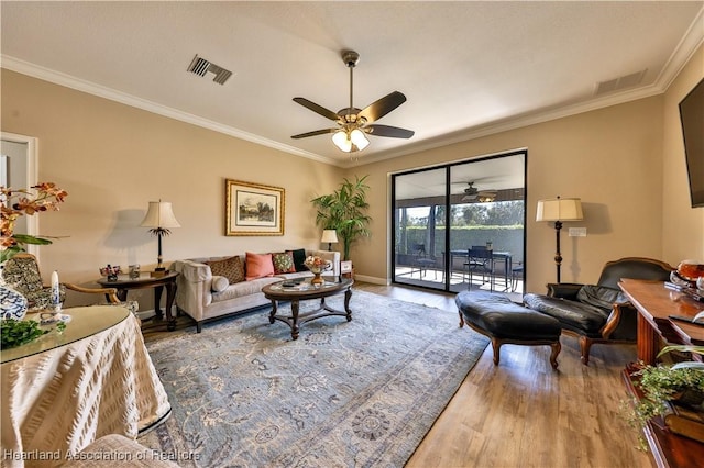 living room featuring wood-type flooring, ceiling fan, and crown molding