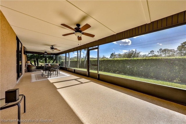 unfurnished sunroom with plenty of natural light and ceiling fan