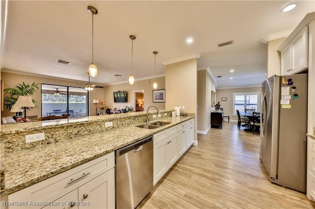 kitchen with white cabinets, hanging light fixtures, sink, appliances with stainless steel finishes, and light stone counters