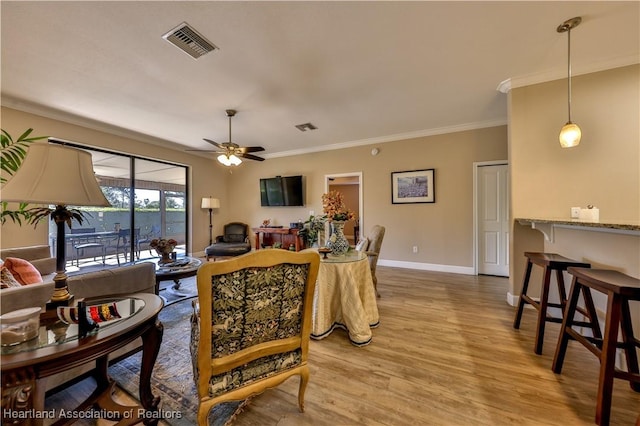 living room with hardwood / wood-style floors, ceiling fan, and crown molding