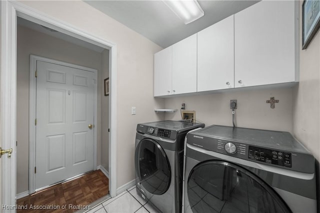laundry room featuring baseboards, washing machine and clothes dryer, and cabinet space