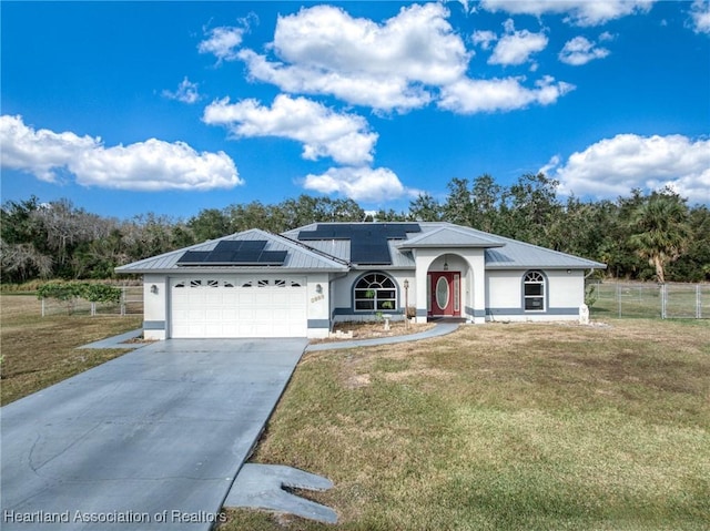 ranch-style home with fence, metal roof, driveway, a front lawn, and a garage