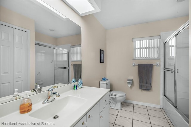 full bathroom with a closet, toilet, vanity, tile patterned flooring, and baseboards