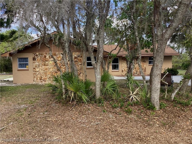 view of side of home with stone siding and stucco siding