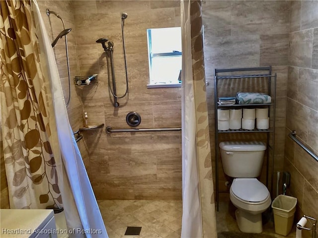 bathroom with toilet and a tile shower
