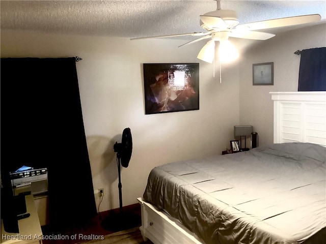 bedroom with a ceiling fan and a textured ceiling