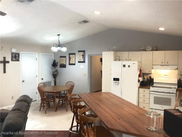 kitchen with lofted ceiling, under cabinet range hood, white appliances, visible vents, and pendant lighting