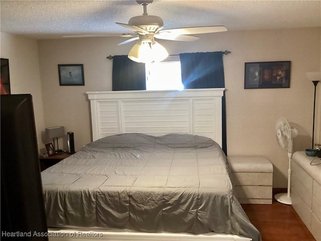 bedroom with ceiling fan, a textured ceiling, and wood finished floors