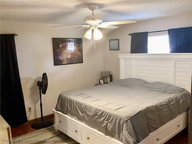 bedroom with a ceiling fan, a textured ceiling, and baseboards