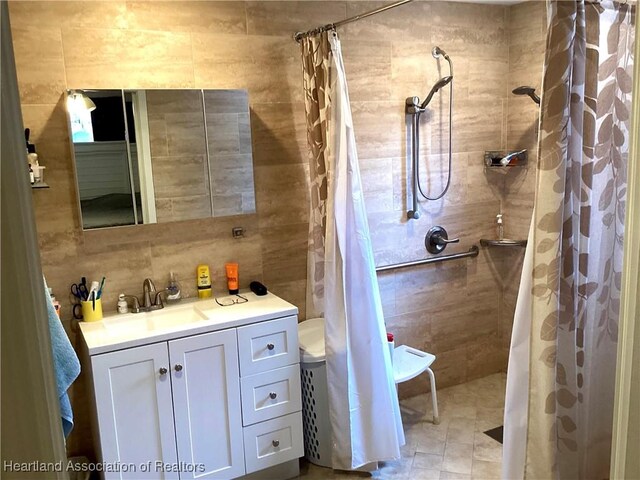 bathroom featuring tiled shower, vanity, tile walls, and decorative backsplash