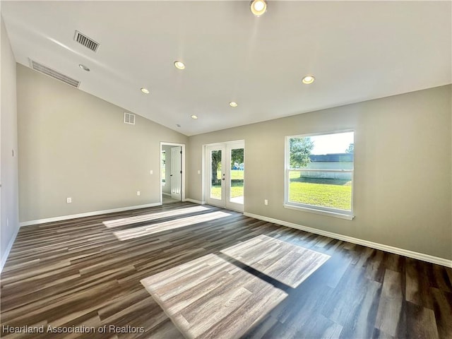 empty room with dark hardwood / wood-style flooring and vaulted ceiling