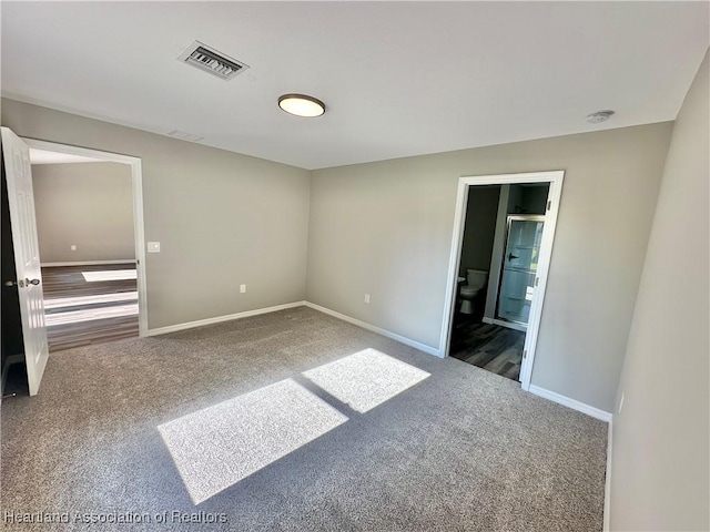 spare room with dark colored carpet