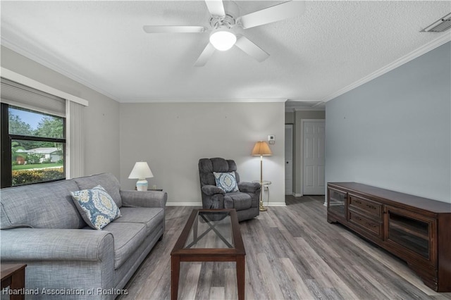 living room with a textured ceiling, ceiling fan, crown molding, and hardwood / wood-style floors