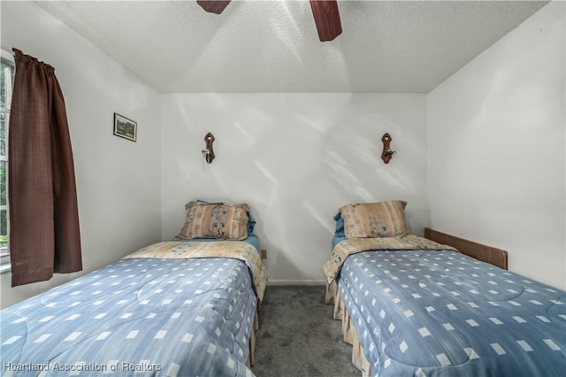 carpeted bedroom with ceiling fan and a textured ceiling