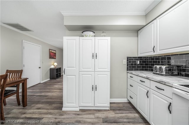 kitchen featuring white cabinets, dark hardwood / wood-style floors, and crown molding