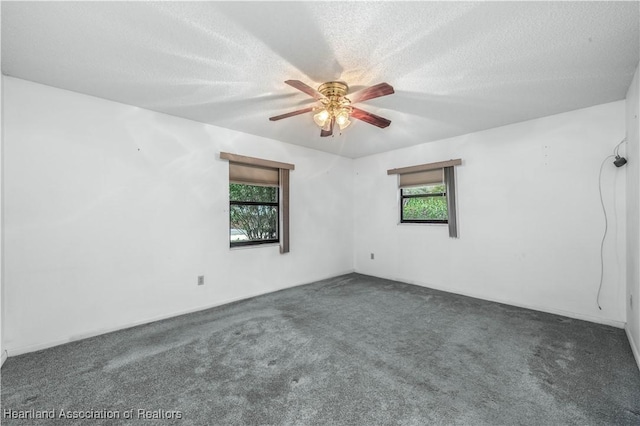 carpeted empty room with ceiling fan and a textured ceiling