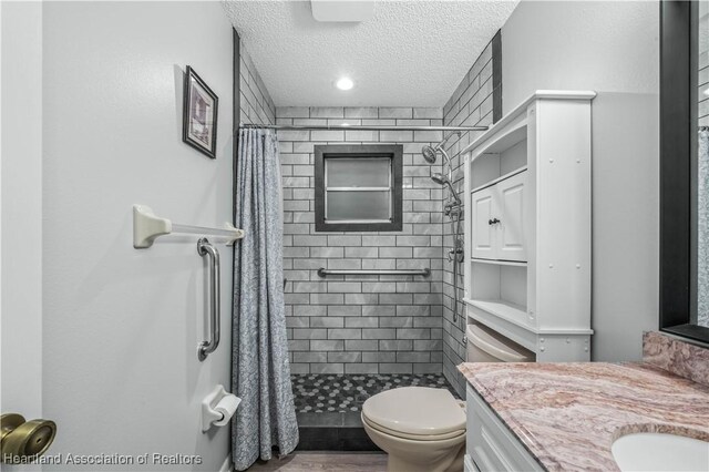 bathroom featuring vanity, a shower with shower curtain, a textured ceiling, and toilet