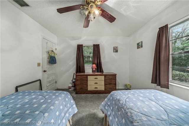 bedroom featuring ceiling fan, light carpet, and a textured ceiling