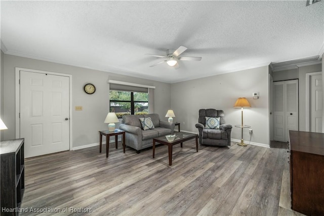 living room with a textured ceiling, ceiling fan, crown molding, and hardwood / wood-style flooring