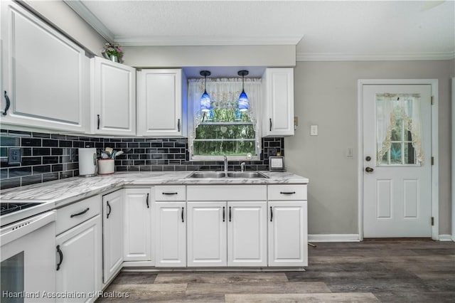 kitchen featuring white cabinets, pendant lighting, light stone counters, and sink