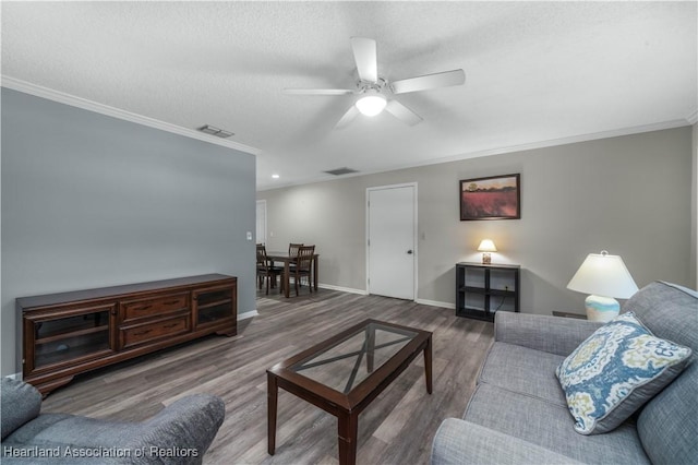 living room featuring crown molding, ceiling fan, and wood-type flooring