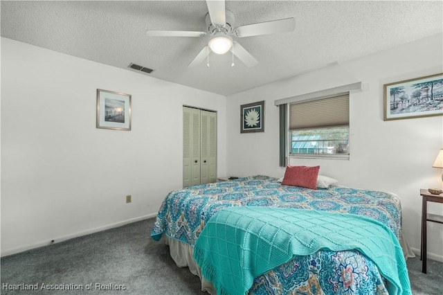 carpeted bedroom with ceiling fan, a textured ceiling, and a closet