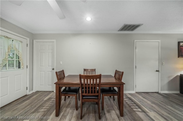 dining room with crown molding and hardwood / wood-style flooring