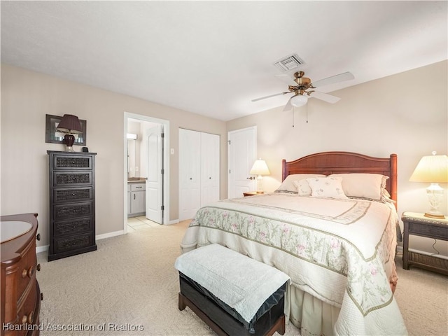 bedroom featuring ceiling fan, a closet, ensuite bath, and light carpet