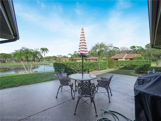 view of patio with grilling area and a water view