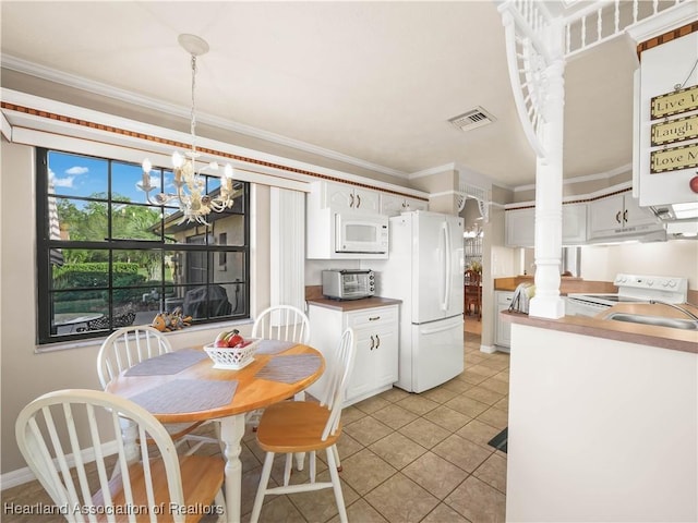 kitchen featuring light tile patterned flooring, white cabinetry, crown molding, an inviting chandelier, and white appliances