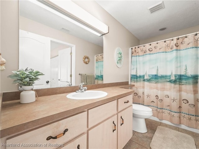 bathroom featuring tile patterned flooring, vanity, and toilet