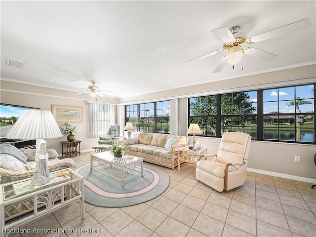 tiled living room with a water view, ceiling fan, and crown molding