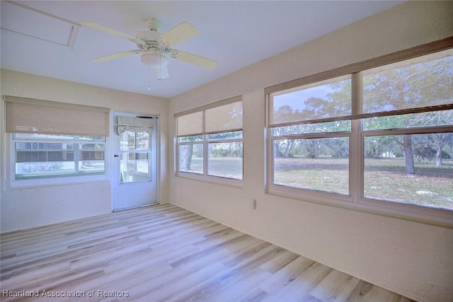 unfurnished sunroom with a ceiling fan