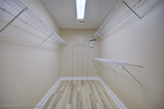 walk in closet with wood finished floors and visible vents