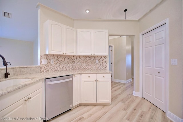 kitchen with visible vents, backsplash, light stone countertops, stainless steel dishwasher, and a sink