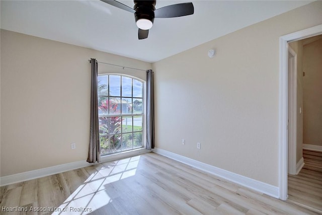 unfurnished room featuring light wood finished floors, baseboards, and a ceiling fan