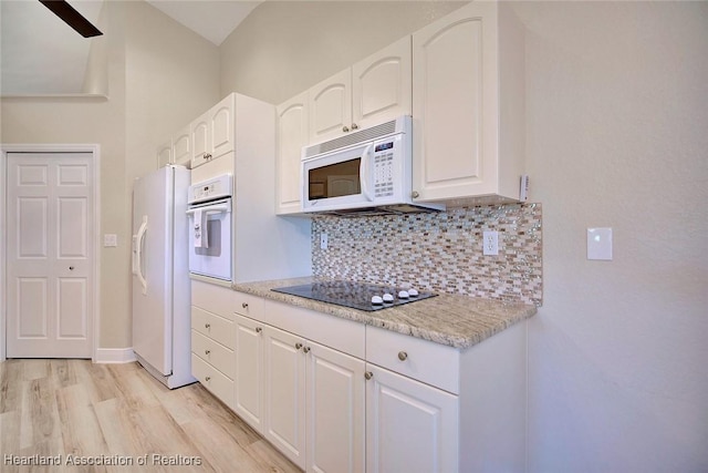 kitchen with light wood-type flooring, white appliances, white cabinets, and backsplash