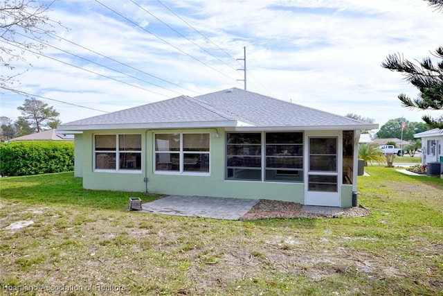 back of property featuring central air condition unit, a shingled roof, a lawn, stucco siding, and a patio area