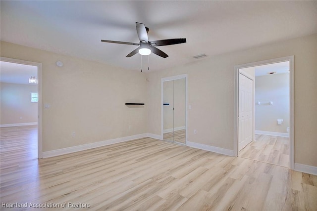 empty room with ceiling fan, baseboards, and wood finished floors