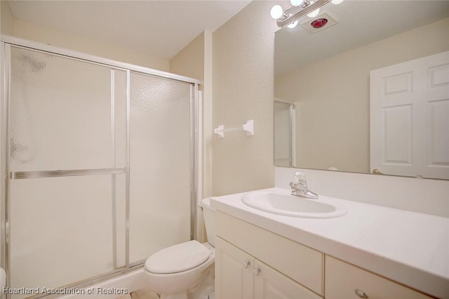 full bath with a stall shower, vanity, and toilet