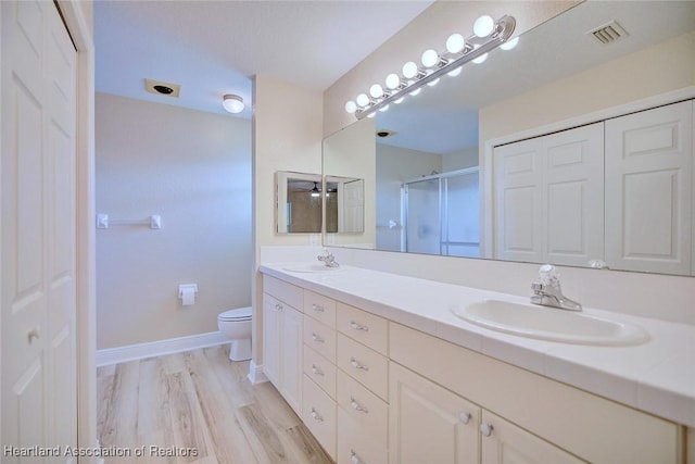 full bathroom featuring a stall shower, visible vents, a sink, and toilet