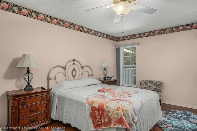 bedroom with ceiling fan, dark hardwood / wood-style flooring, and a textured ceiling