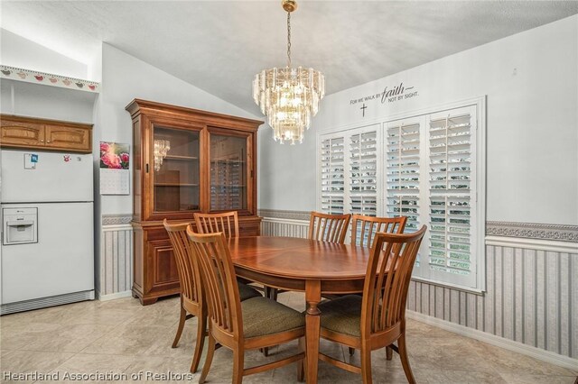 dining space with a chandelier and vaulted ceiling