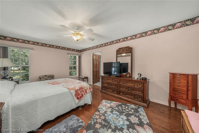 bedroom featuring a textured ceiling, ceiling fan, and dark wood-type flooring