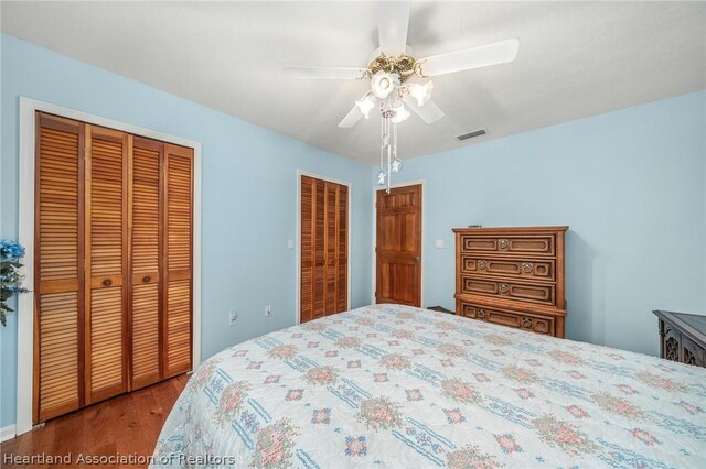 bedroom featuring ceiling fan and two closets