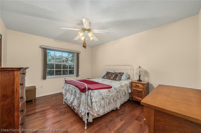 bedroom with a textured ceiling, dark hardwood / wood-style flooring, and ceiling fan