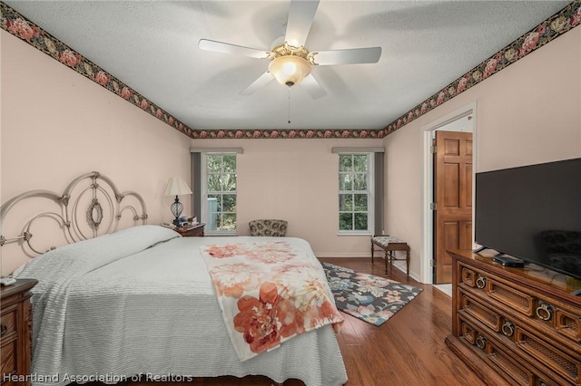 bedroom with hardwood / wood-style floors, a textured ceiling, and ceiling fan