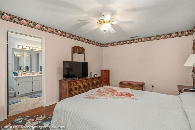 bedroom featuring ceiling fan, sink, and ensuite bathroom