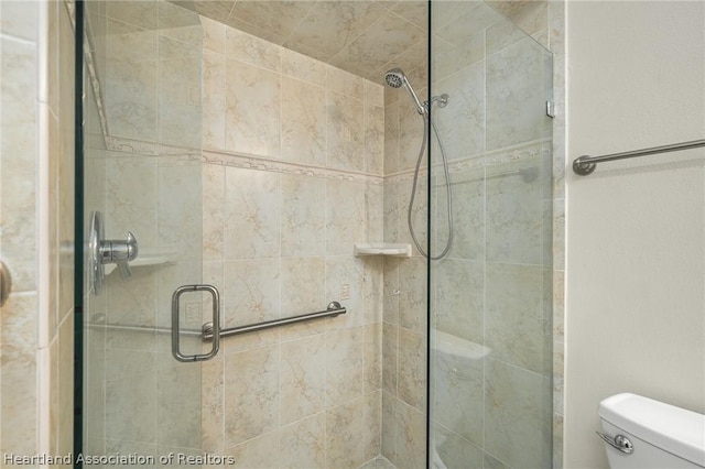 bathroom featuring toilet and an enclosed shower