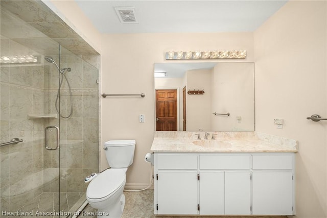 bathroom with tile patterned floors, vanity, toilet, and a shower with door